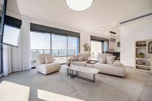 Uma sala de estar moderna com um conjunto de sofás, uma mesa de centro e uma área de jantar.