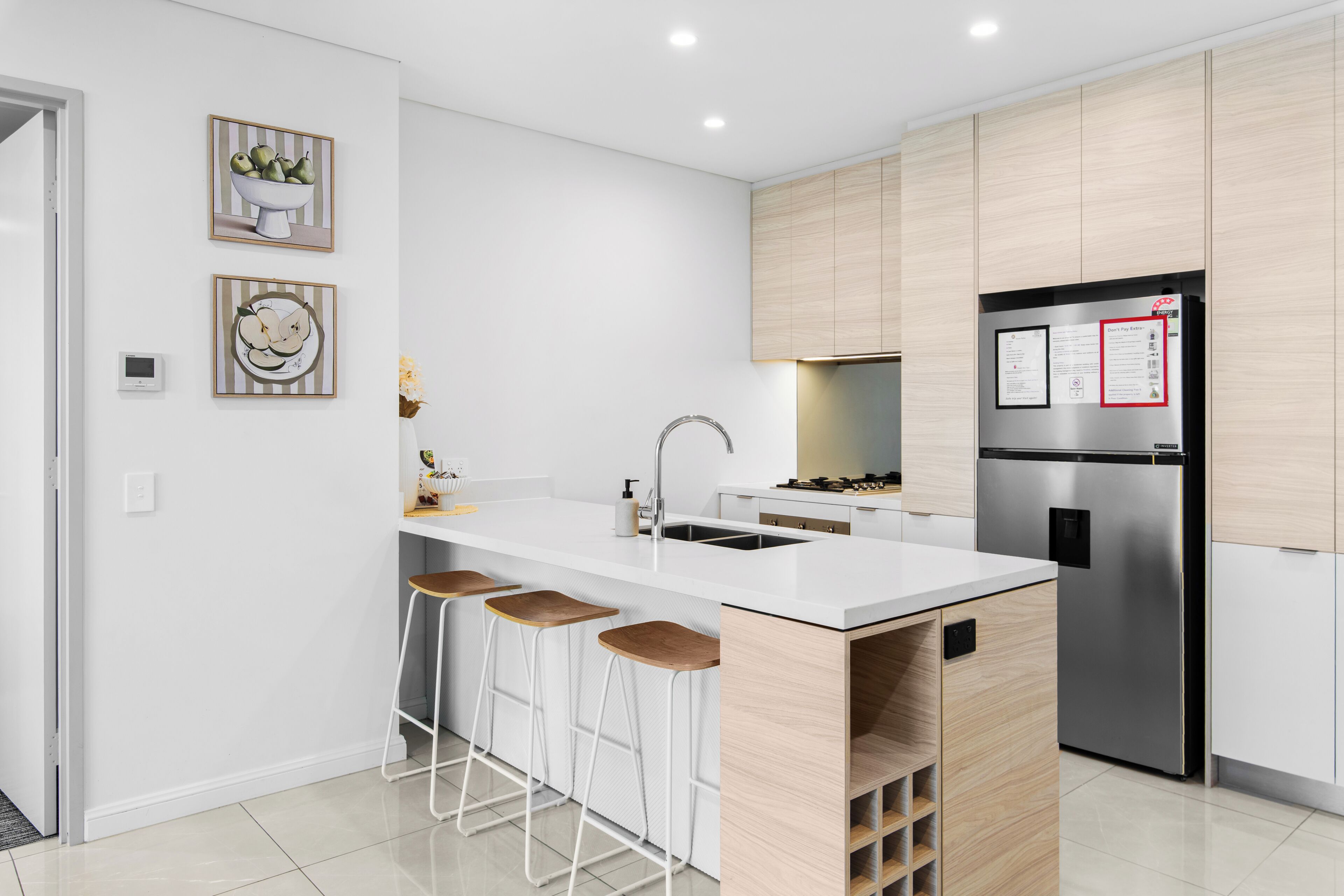 A modern kitchen with a central island, stainless steel appliances, and wooden cabinetry.