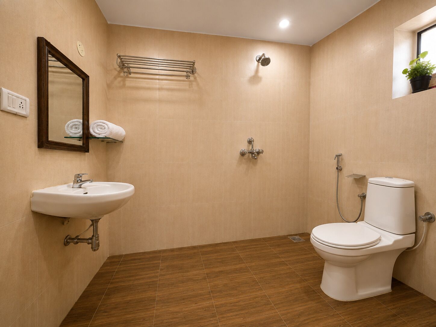 Un baño con lavamanos, inodoro, ducha y espejo.