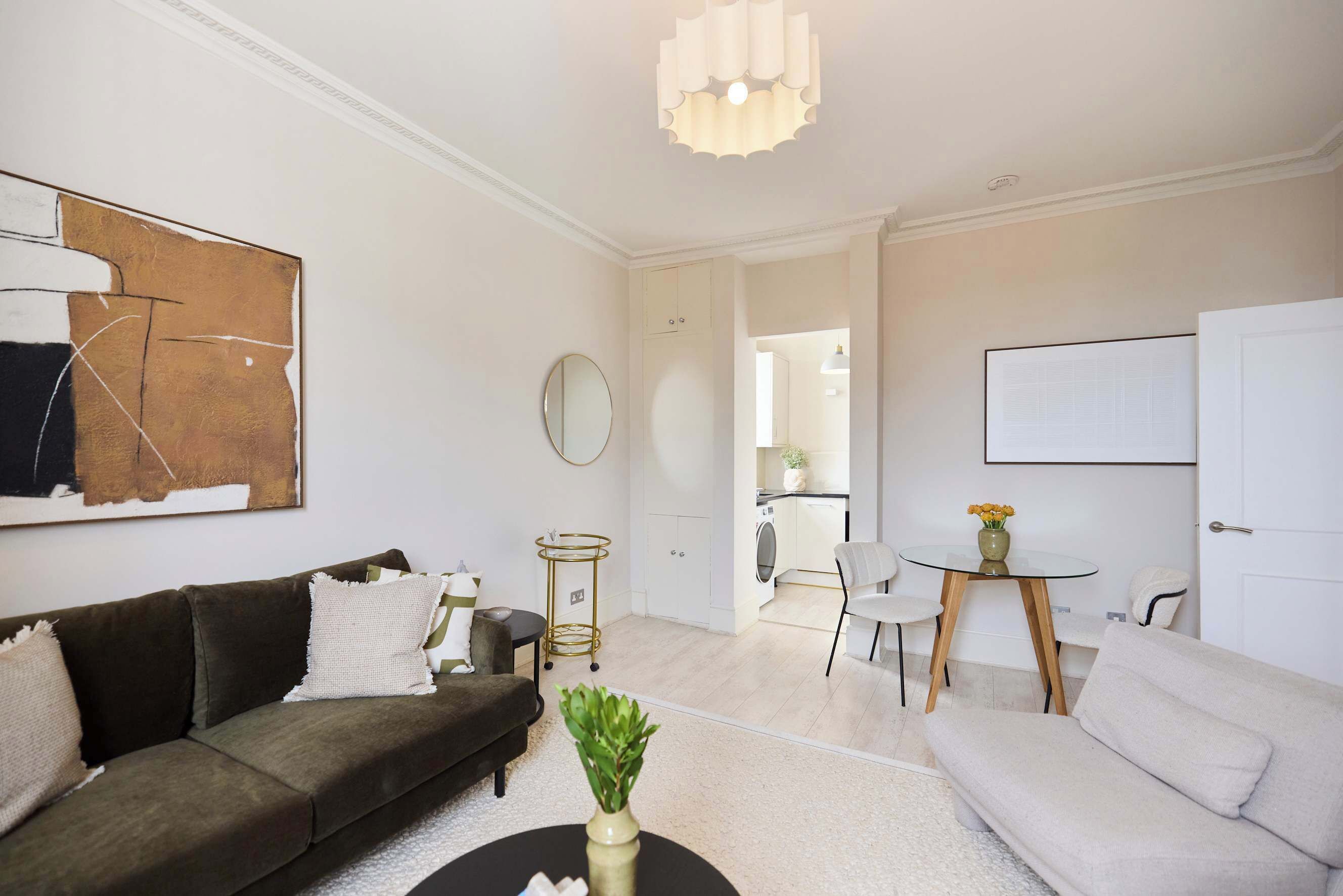 A living room with a sofa, coffee table, and a dining area with a table and chairs.