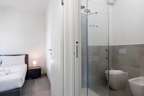 Un bagno moderno con doccia vetrata, un WC e un bidet.