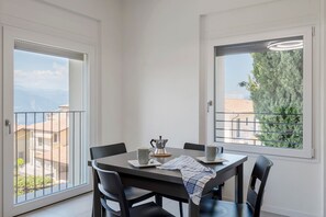 Zona pranzo con tavolo, sedie, caffettiera e tazze.