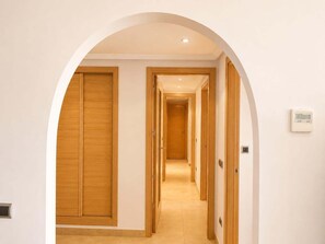 Ein Flur mit Holztüren und einem Thermostat an der Wand.