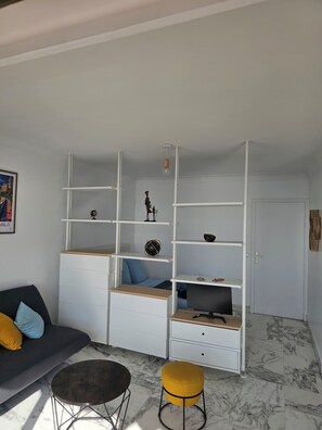 Ein modernes Wohnzimmer mit einer Couch, einem Couchtisch, einem Fernseher und integrierten Regalen.