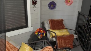 A cozy room with two rocking chairs, a patterned rug, and decorative flowers on the wall. - Cozy 1-bedroom apartment with AC in lovely Frisco (Frisco)