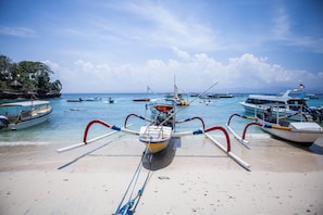 A beach with boats docked and a clear sky. - The Nicho’s Bungalows and Villas (Kabupaten Klungkung)