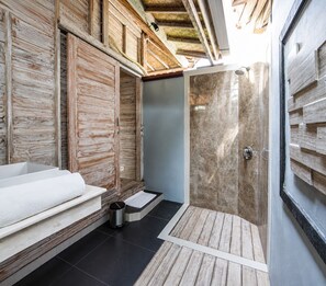 A modern bathroom with a wooden wall, a shower, and a bathtub. - The Nicho’s Bungalows and Villas (Kabupaten Klungkung)