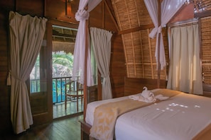 A wooden room with a bed, curtains, and a balcony. - The Nicho’s Bungalows and Villas (Kabupaten Klungkung)