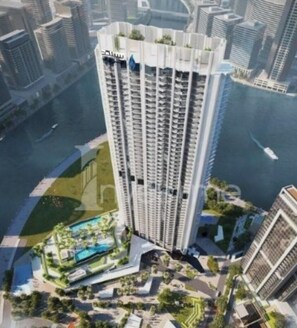 Ein Hochhaus mit Poolanlage und Grünflächen am Fuße des Gebäudes.
