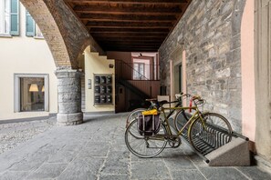 A stone staircase leading to an upper level, a bicycle parked against a wall, and a stone pillar. - Nucia Studio in the heart of Como (Como)