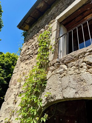Un edificio de piedra con una ventana y una puerta.