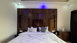 A modern bedroom with a large bed, wooden headboard, and a ceiling fan.