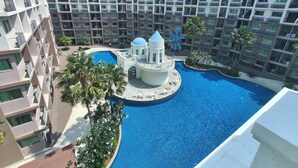 Un hotel con piscina centrale, numerosi balconi e una caratteristica struttura a mulino blu.