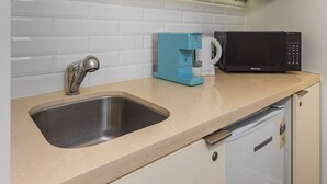 A compact kitchenette with a sink, a coffee maker, a microwave, and a small refrigerator. - Imperial Hotel Paddington (Paddington)