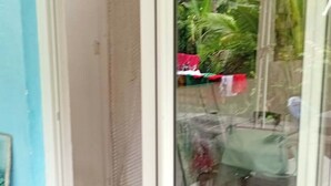 Een kamer met een schuifdeur naar een buitenruimte met betegelde vloer en een kleine tuin.
