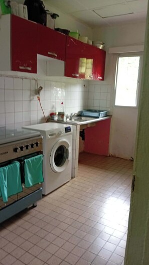 Una cocina con lavadora, un lavabo y una ventana.