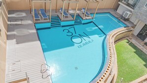 Una piscina en la azotea con sillas de descanso, un letrero con el número '37' y el rótulo 'KIK AMBALA'.