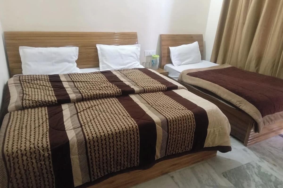 Una habitación de hotel con una cama grande, dos mesitas de noche y una cortina.