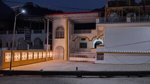Un hotel con ingresso carrabile, un'area coperta illuminata e una targa.