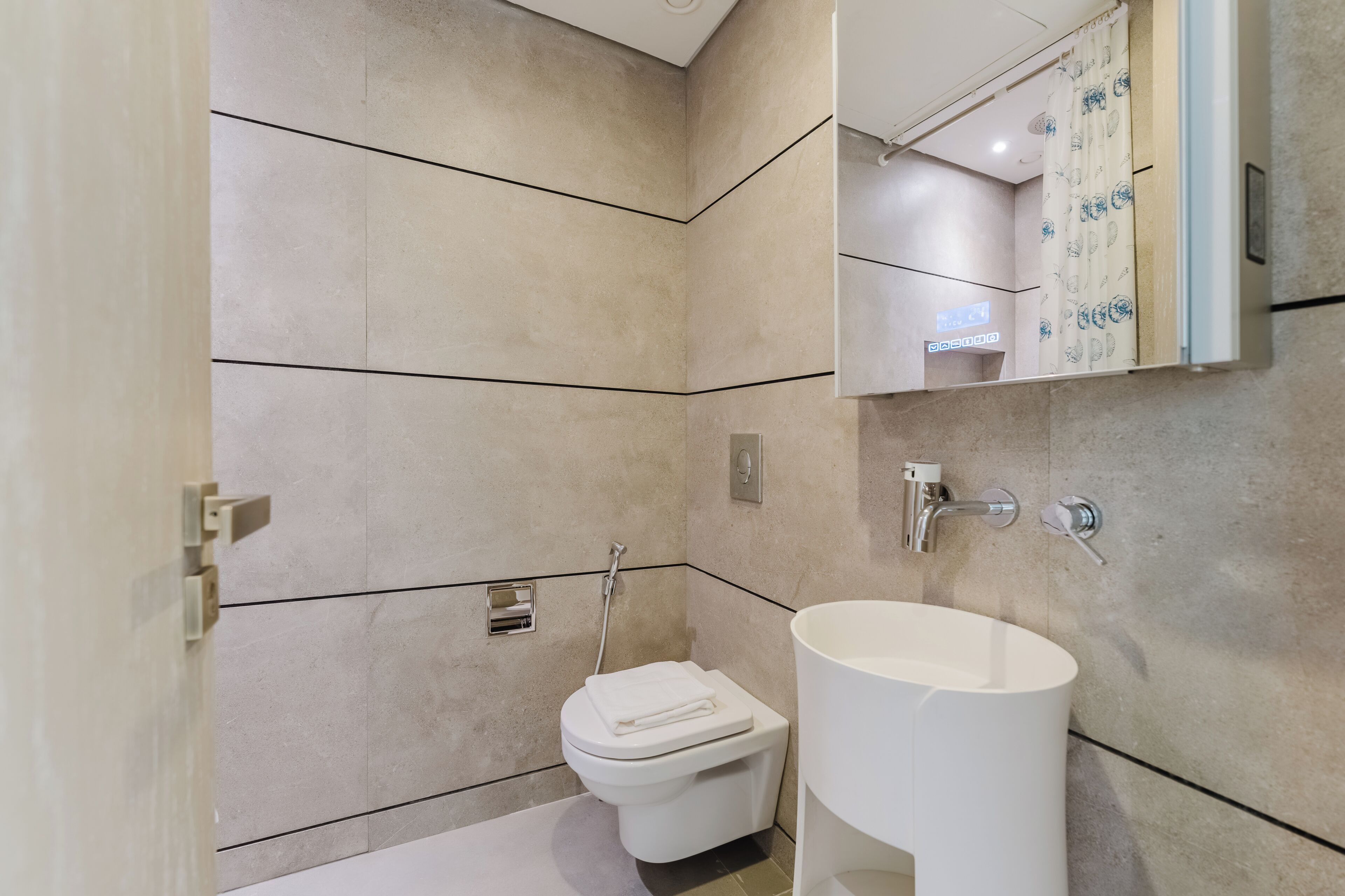 A modern bathroom with a toilet, a sink, and a shower.