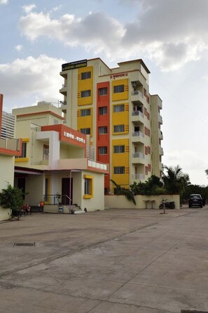 A multi-story building with balconies, a flat roof, and a clear sky. - Vibestayz Omkar Hinjawadi (Pune)