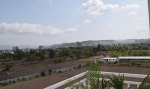 A residential area with buildings, trees, and a clear sky. - Vibestayz Omkar Hinjawadi (Pune)
