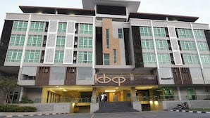 Un edificio moderno con una entrada destacada, varios pisos y un elemento vertical central.