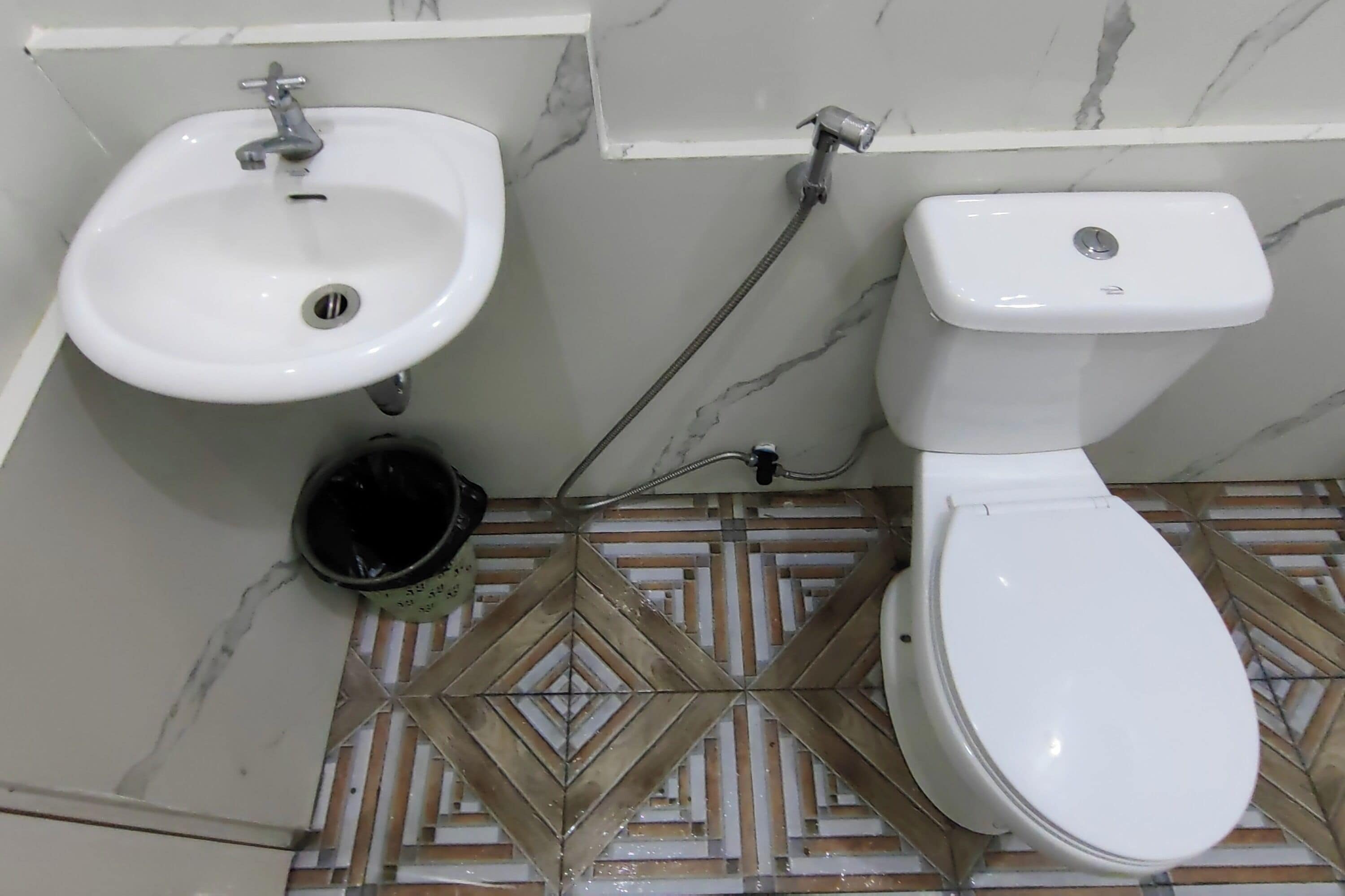 Ein Badezimmer mit Waschbecken, Toilette und Duschkopf.