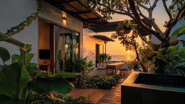 A modern outdoor patio with a view of the ocean, wooden decking, and various plants. - Ma'S Sea Beach House (Krabi)
