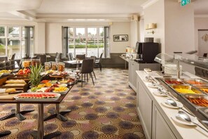 En hotellrestaurang med en buffé, en tv och utsikt över omgivningarna.