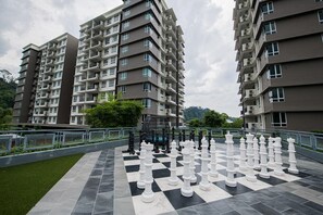 A chessboard with pieces set up on a rooftop terrace, surrounded by residential buildings.