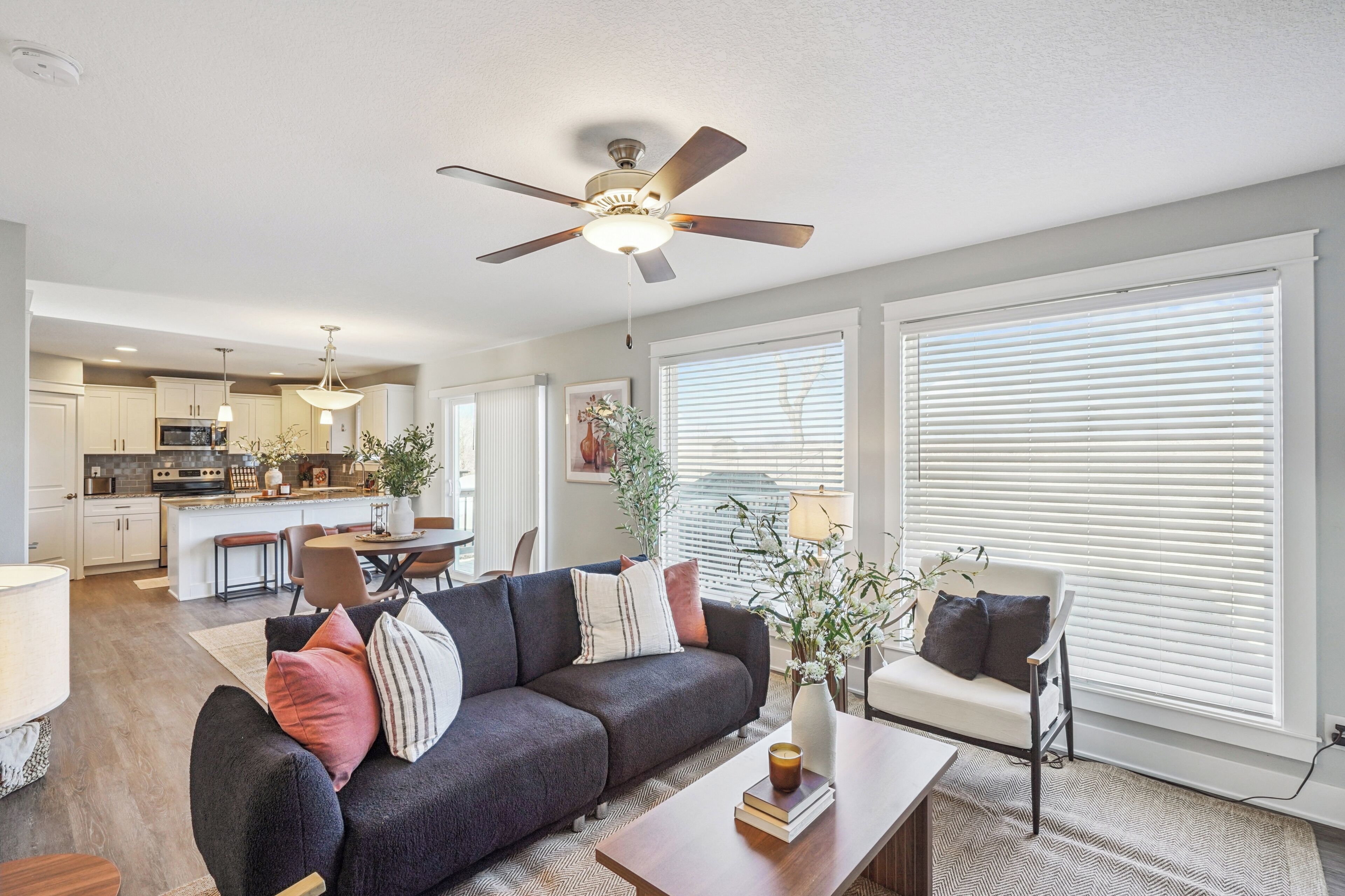 A modern living room with a sofa, coffee table, and a ceiling fan.