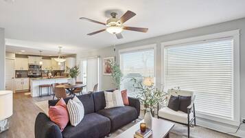 A modern living room with a sofa, coffee table, and a ceiling fan.