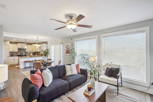 A modern living room with a sofa, coffee table, and a ceiling fan.