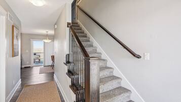 A staircase with wooden handrails and carpeted steps leading to a room with a view.