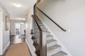Una escalera de madera con barandillas y peldaños alfombrados que conduce a una habitación con vistas.