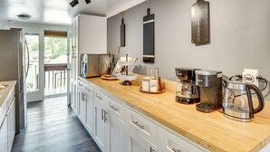 A modern kitchen with a wooden countertop, stainless steel appliances, and a view to the outdoors. - Waterfront Cabin w/ Stunning Sound Views (University Place)