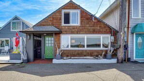 A house with a sloped roof, a front porch, and a garage. - Waterfront Cabin w/ Stunning Sound Views (University Place)