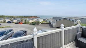 Ein Küsten-Caravanpark mit mehreren Wohnwagen, einem Parkplatz und Blick auf das Meer.