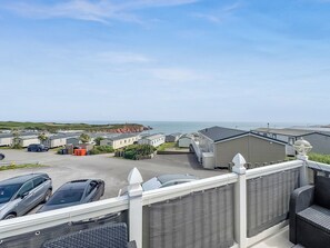 Ein Küsten-Caravanpark mit mehreren Wohnwagen, einem Parkplatz und Blick auf das Meer.
