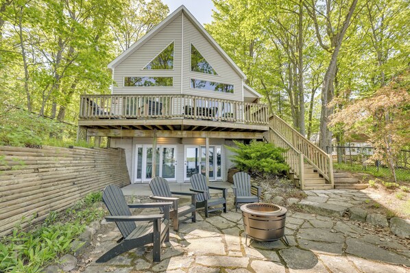 A two-story house with a deck, outdoor seating, and a fire pit. - Private Duck Lake Access: Up North Getaway (Interlochen)