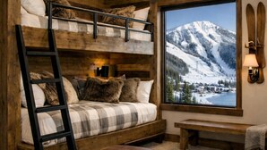 A bunk bed room with a mountain view, a bench, and a lamp. - Ski-in Ski-out, hot tub, on the ski run, next to the chairlift. Epic views! #2 (Sandpoint)