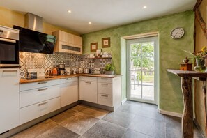 A modern kitchen with a microwave, stove, and cabinets. - Historic Farmhouse I Chimney I Terrace I Kitchen (Hillesheim)