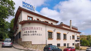 En byggnad med en skylt som visar texten ”Hotel Restaurante Asador Carnes a La Brasa”.