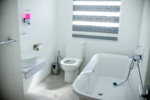 Une salle de bain avec des toilettes, un lavabo et une baignoire.