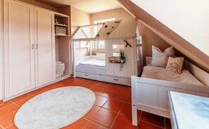 A bedroom with a bunk bed, a desk, a white wardrobe, and a large window. - Vacation apartment close to the beach with its own terrace - Feriendorf Bakenberg FeWo A28 - (Dranske)