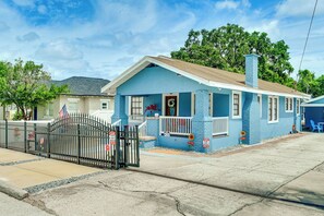 Ein eingeschossiges Haus mit Veranda, Garage und einer kleinen Auffahrt.
