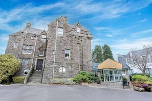 A stone building with a modern glass entrance, a staircase, and a sign reading 'The Landmark.'