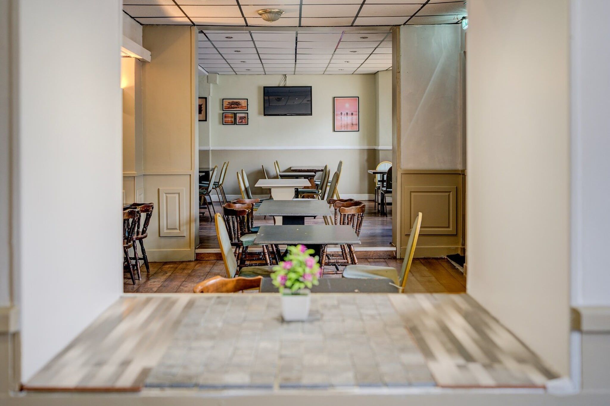 A conference room with a large table, chairs, and a television on the wall.