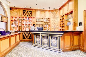 A reception area with wooden cabinetry, a reception desk, and a tiled floor. - Standard Single Room - Shared (London)